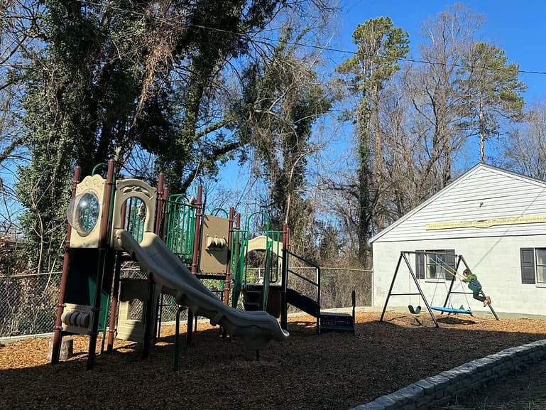 A child exploring independently on the preschool playground
